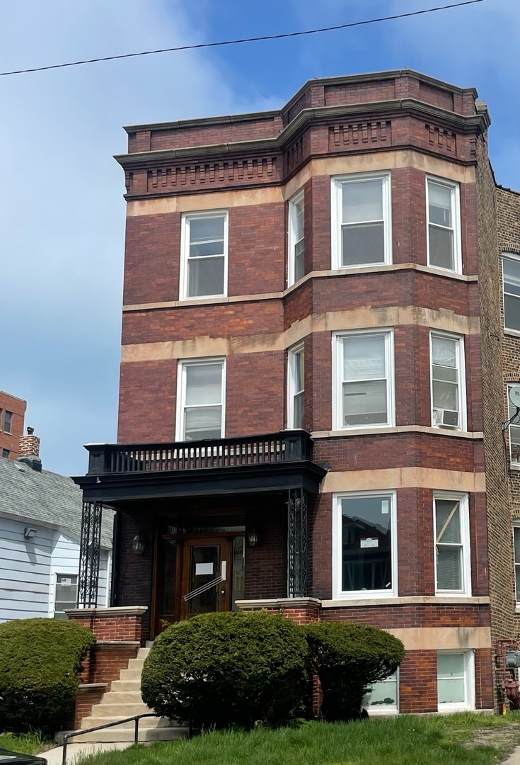 a front view of a residential apartment building with a yard