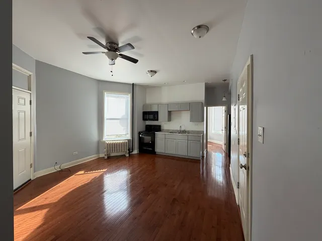 a view of a kitchen with a sink dishwasher cabinets and wooden floor