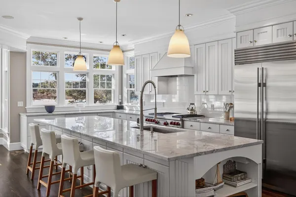 a kitchen with stainless steel appliances granite countertop a sink a stove and a refrigerator