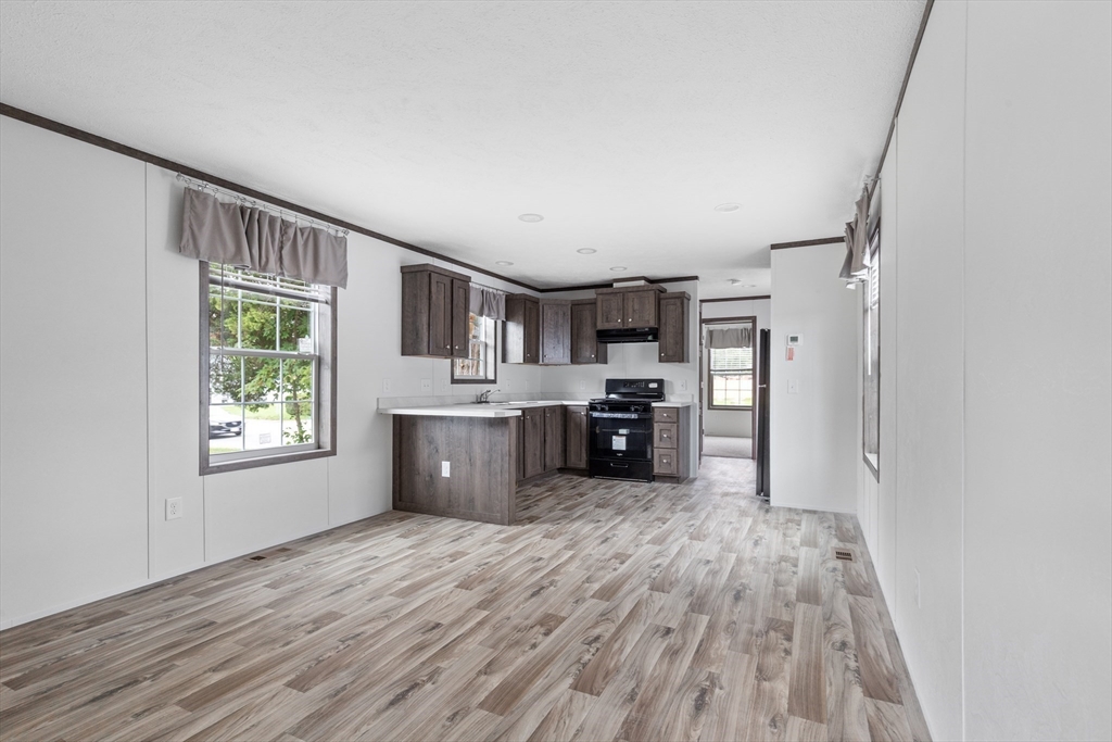 4 Sam Street Acushnet, MA 02743 - Photo 4 of 10 a kitchen with stainless steel appliances kitchen island wooden floors and view living room