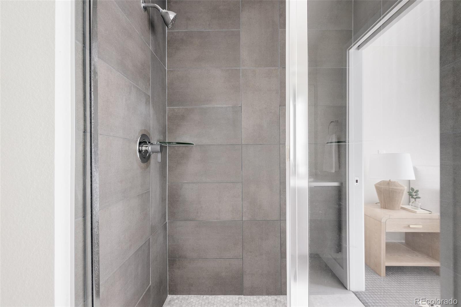 1179 South Reed Street Lakewood, CO 80232 - Photo 17 of 27 a bathroom with a glass shower door
