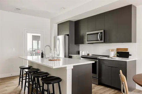 a kitchen with stainless steel appliances a stove a sink refrigerator and microwave
