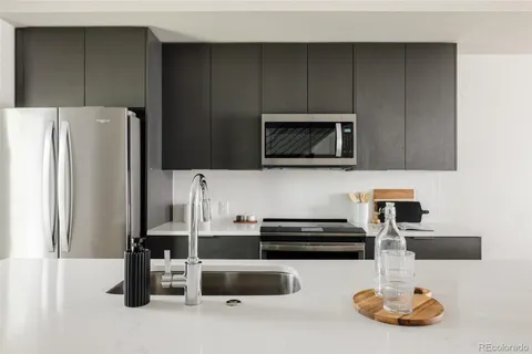 a kitchen with stainless steel appliances a microwave a refrigerator and cabinets