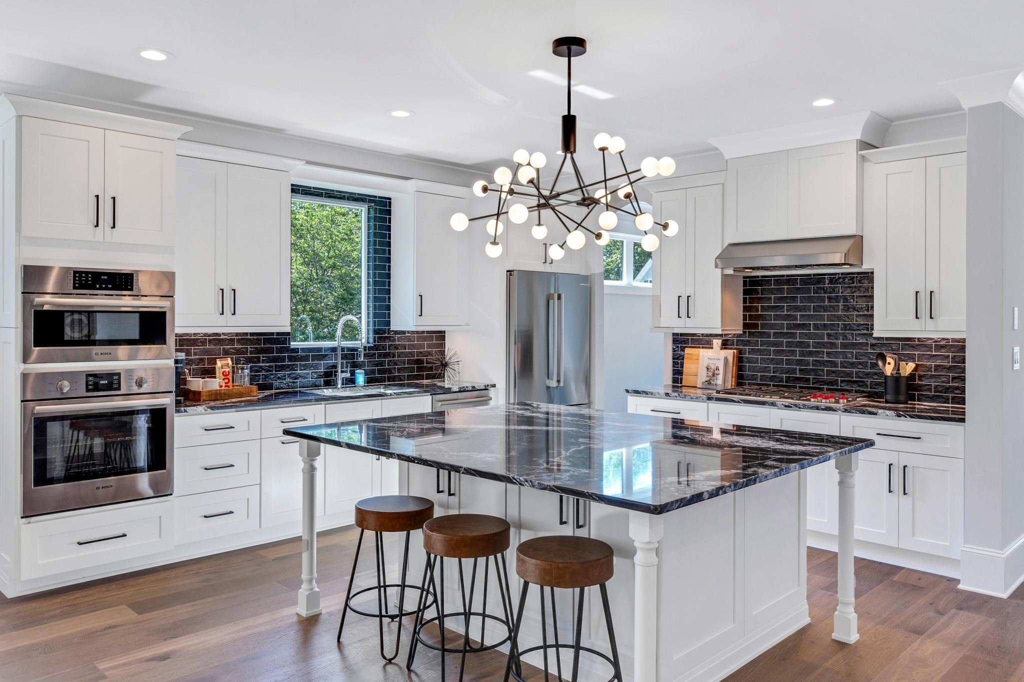115 Crestview Road Raleigh, NC 27609 - Photo 5 of 42 a kitchen with stainless steel appliances a kitchen island hardwood floor sink stove and microwave