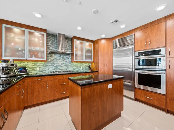 a kitchen with stainless steel appliances granite countertop a stove a sink and a refrigerator