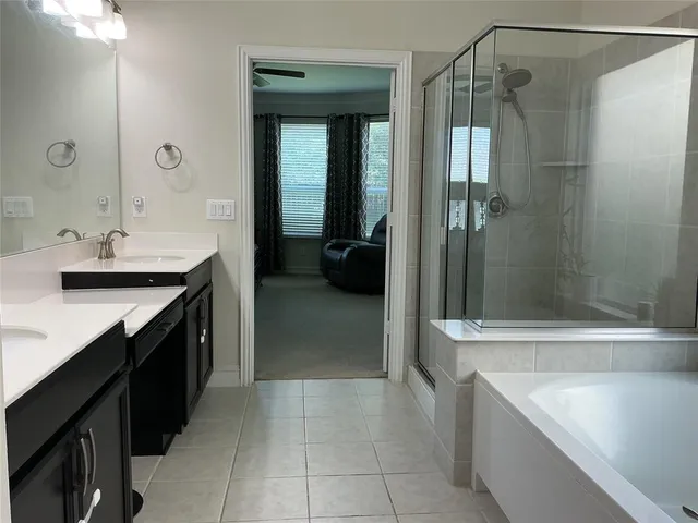 a spacious bathroom with a tub sink and mirror