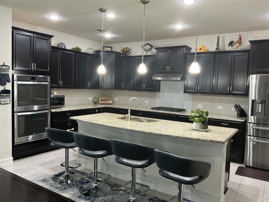 2344 Candler Club Way Little Elm, TX 75068 - Photo 3 of 14 a kitchen with a sink cabinets and stainless steel appliances