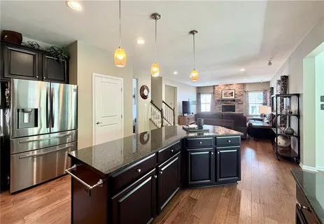 a kitchen with stainless steel appliances granite countertop a stove a refrigerator and a wooden floors