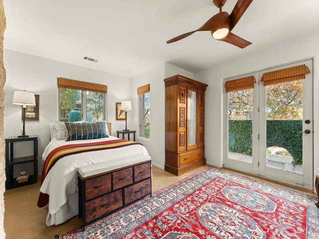 a bedroom with a bed and large windows