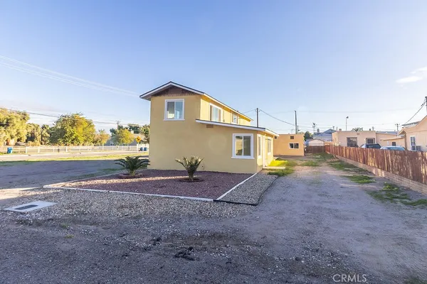 a view of dirt yard with a house