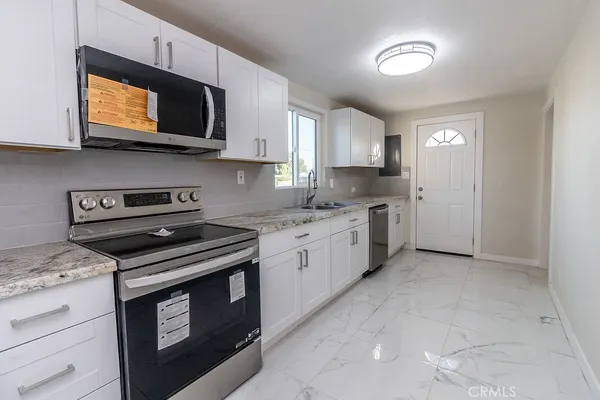 a kitchen with stainless steel appliances granite countertop a sink a stove a microwave and cabinets