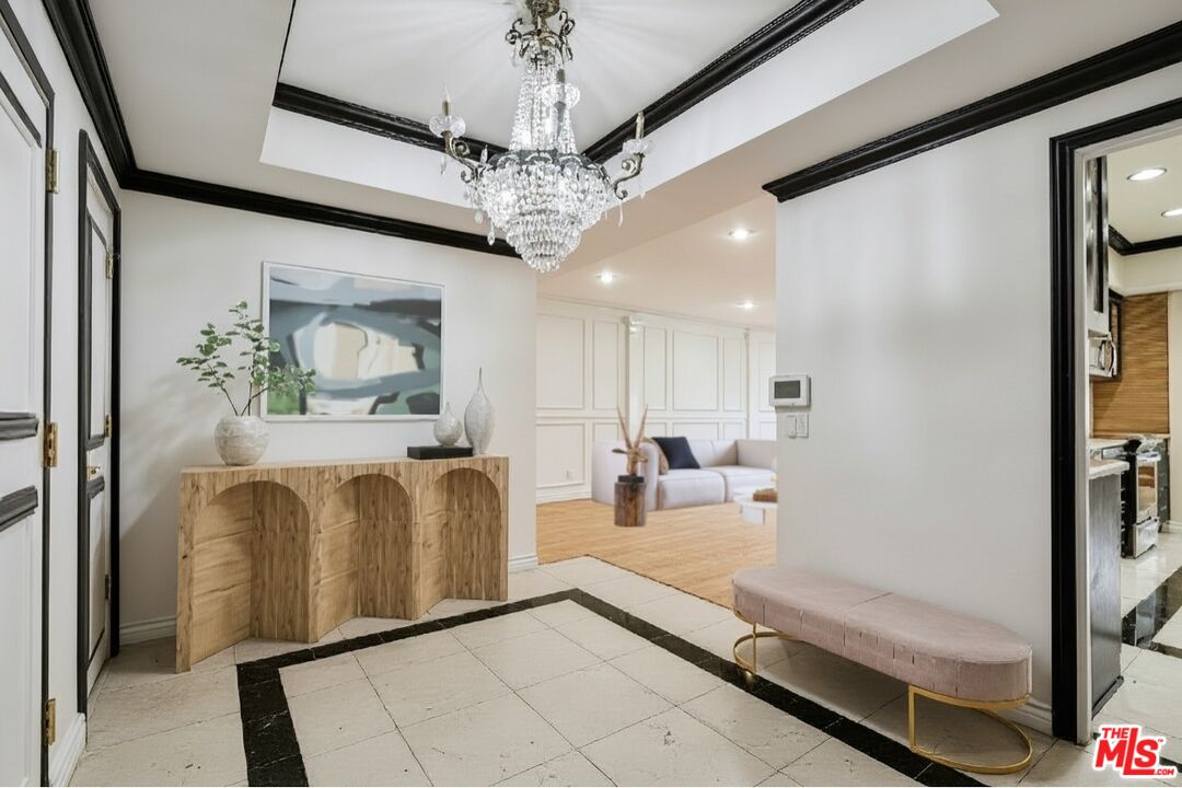 1124 North Kings Road, Unit 102 West Hollywood, CA 90069 - Photo 11 of 26 a living room with furniture and a chandelier