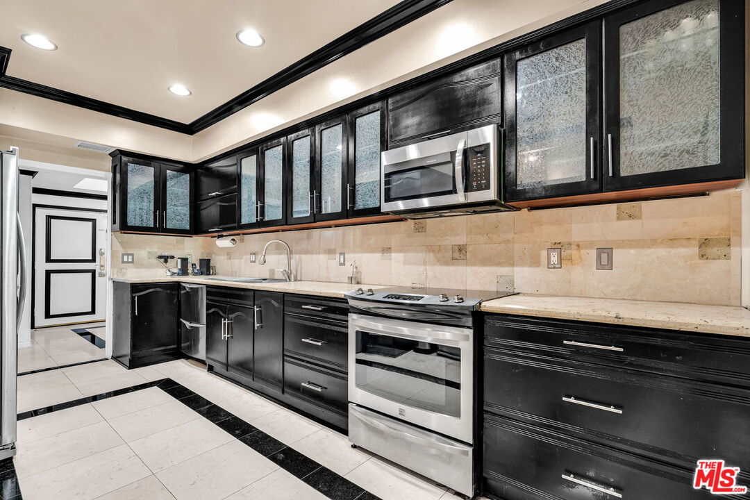 1124 North Kings Road, Unit 102 West Hollywood, CA 90069 - Photo 3 of 26 a kitchen with stainless steel appliances granite countertop a stove and a sink