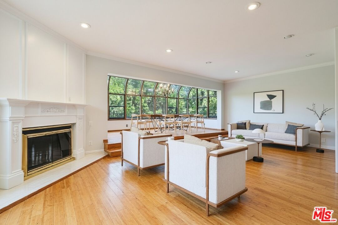 1124 North Kings Road, Unit 102 West Hollywood, CA 90069 - Photo 8 of 26 a living room with stainless steel appliances granite countertop furniture wooden floor and a fireplace