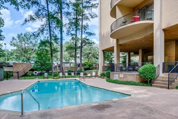 swimming pool view with plants and large trees