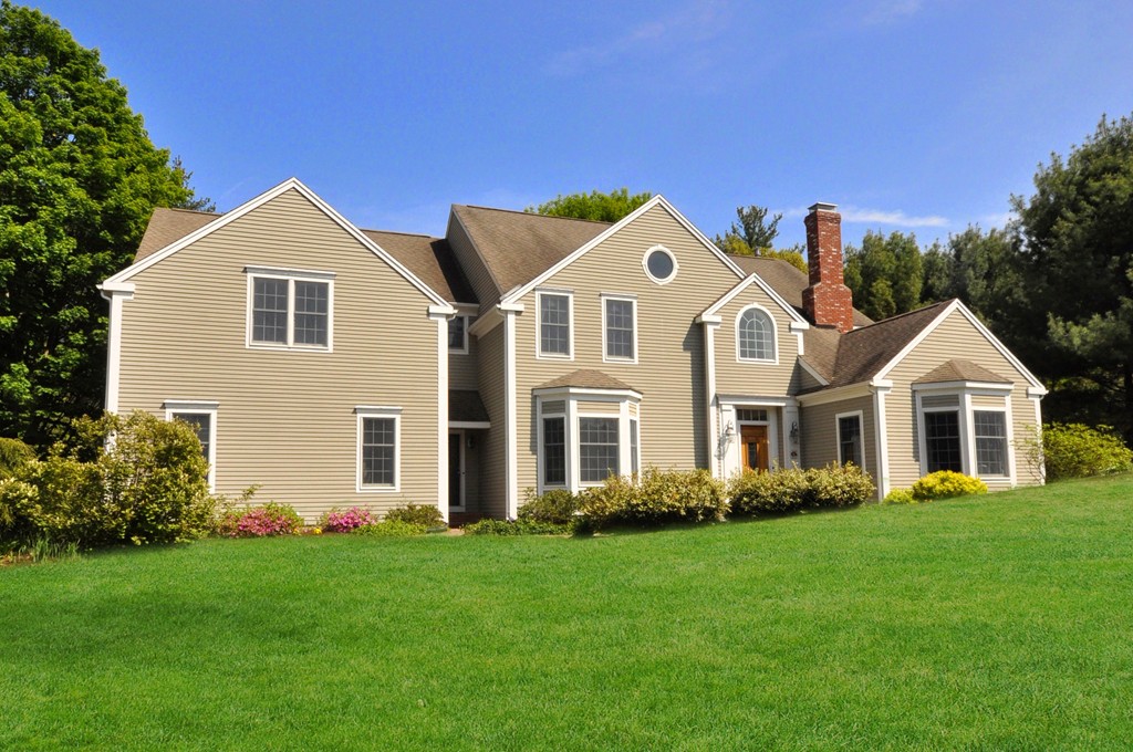a front view of a house with a yard and trees