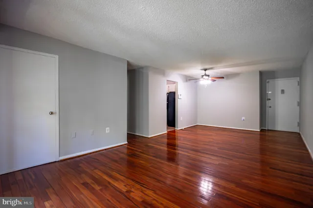 a view of empty room with wooden floor