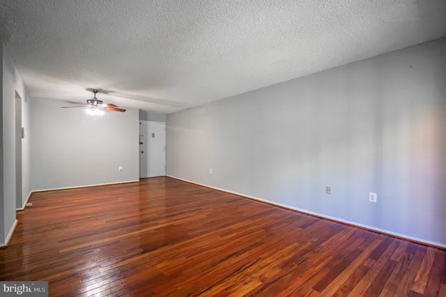 a view of empty room with wooden floor