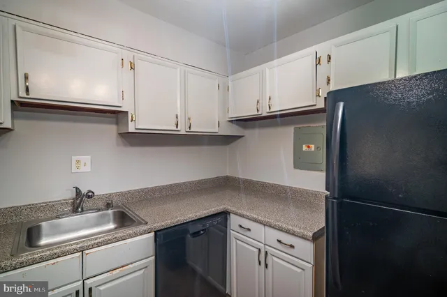 a kitchen with granite countertop white cabinets and a sink