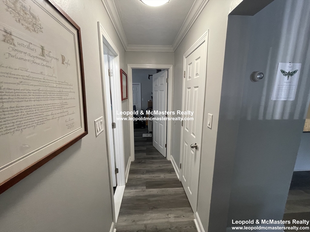 519 Washington Street, Unit 0A Brookline, MA 02446 - Photo 7 of 9 a view of a hallway with wooden floor and staircase