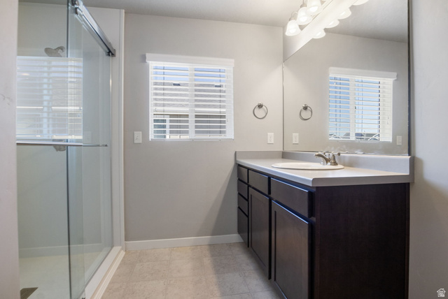 5155 East Rio Grande Way Eagle Mountain, UT 84005 - Photo 21 of 40 Full bathroom featuring vanity, a stall shower, and healthy amount of natural light
