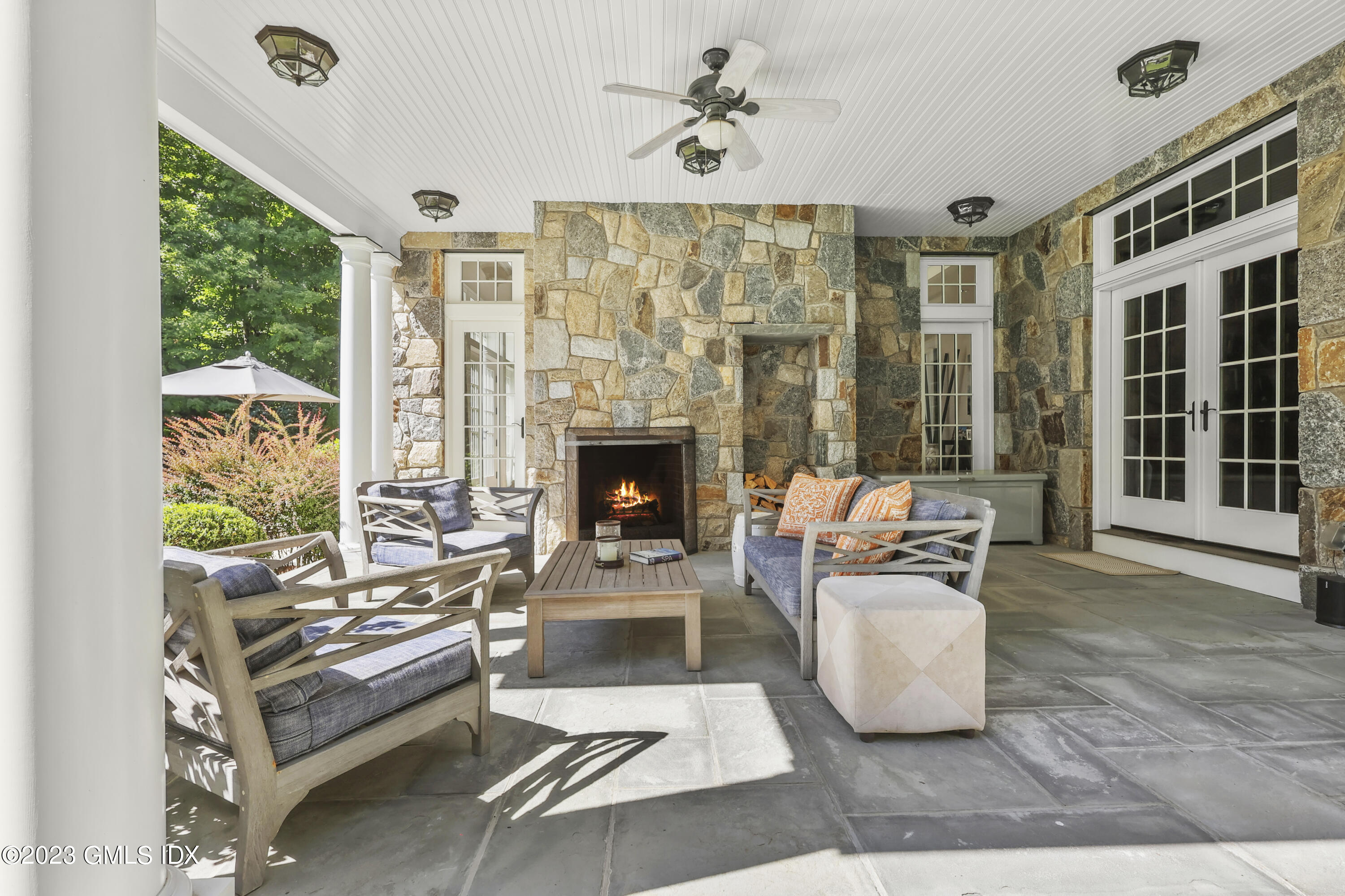 39 Boulder Brook Road Greenwich, CT 06830 - Photo 32 of 55 a living room with furniture a fireplace and a floor to ceiling window