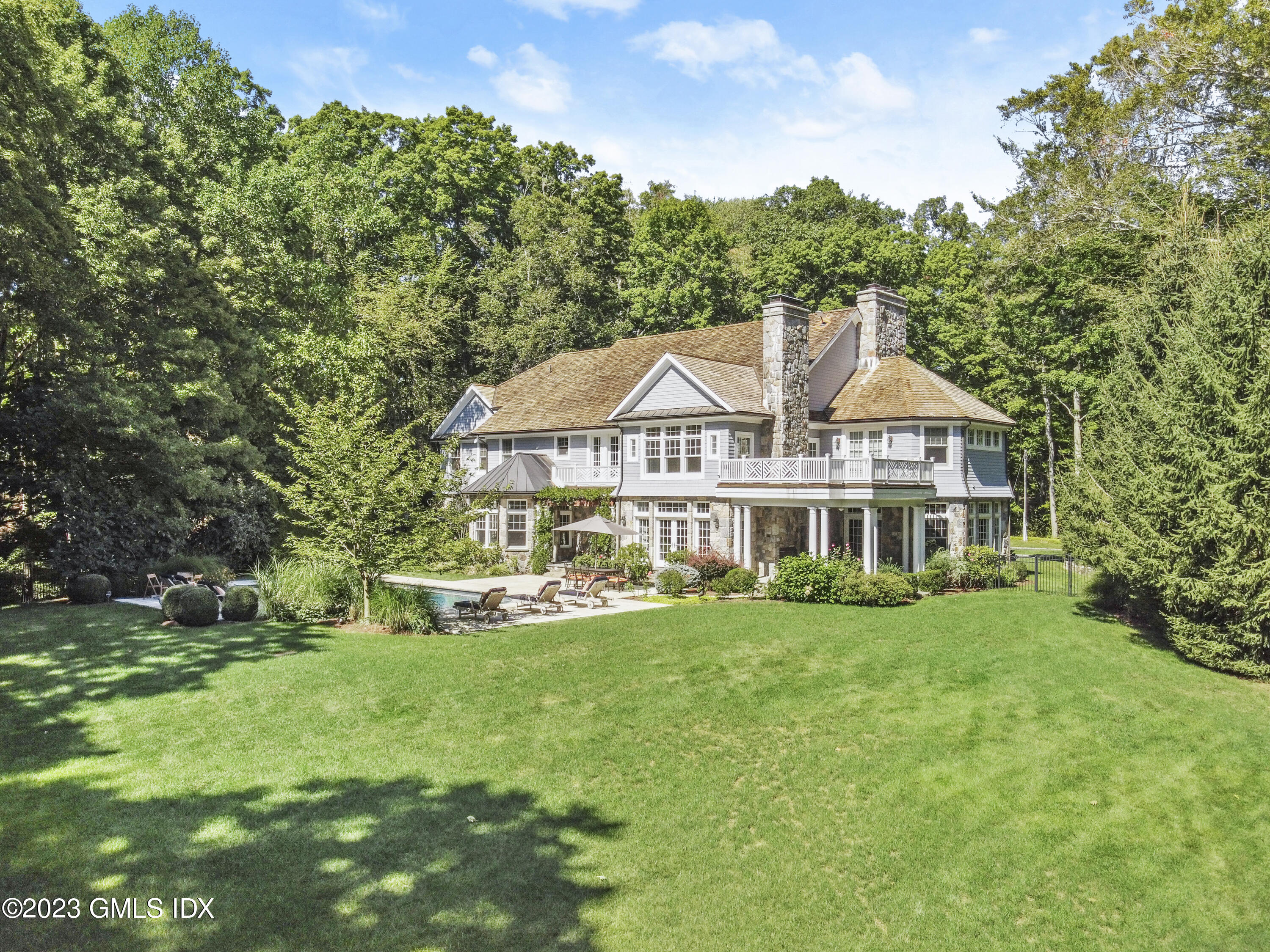 39 Boulder Brook Road Greenwich, CT 06830 - Photo 35 of 55 a view of a house with a yard table and chairs