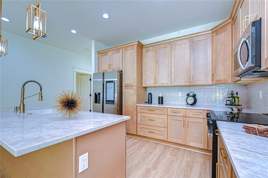 3213 West Aileen Street Tampa, FL 33607 - Photo 21 of 31 a kitchen with stainless steel appliances granite countertop a stove top oven a sink and dishwasher with wooden floor