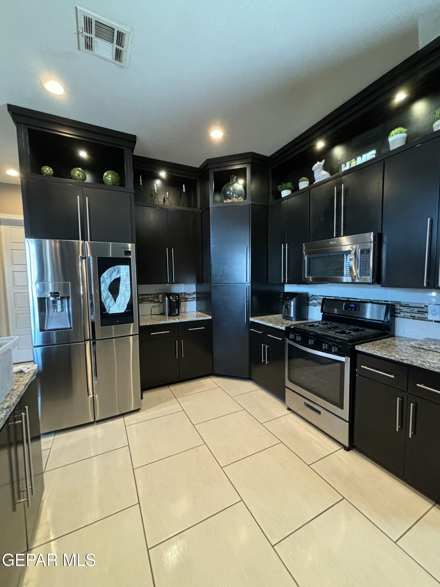 317 Rio Del Rancho Court El Paso, TX 79932 - Photo 3 of 25 a kitchen with stainless steel appliances kitchen island granite countertop a sink and cabinets