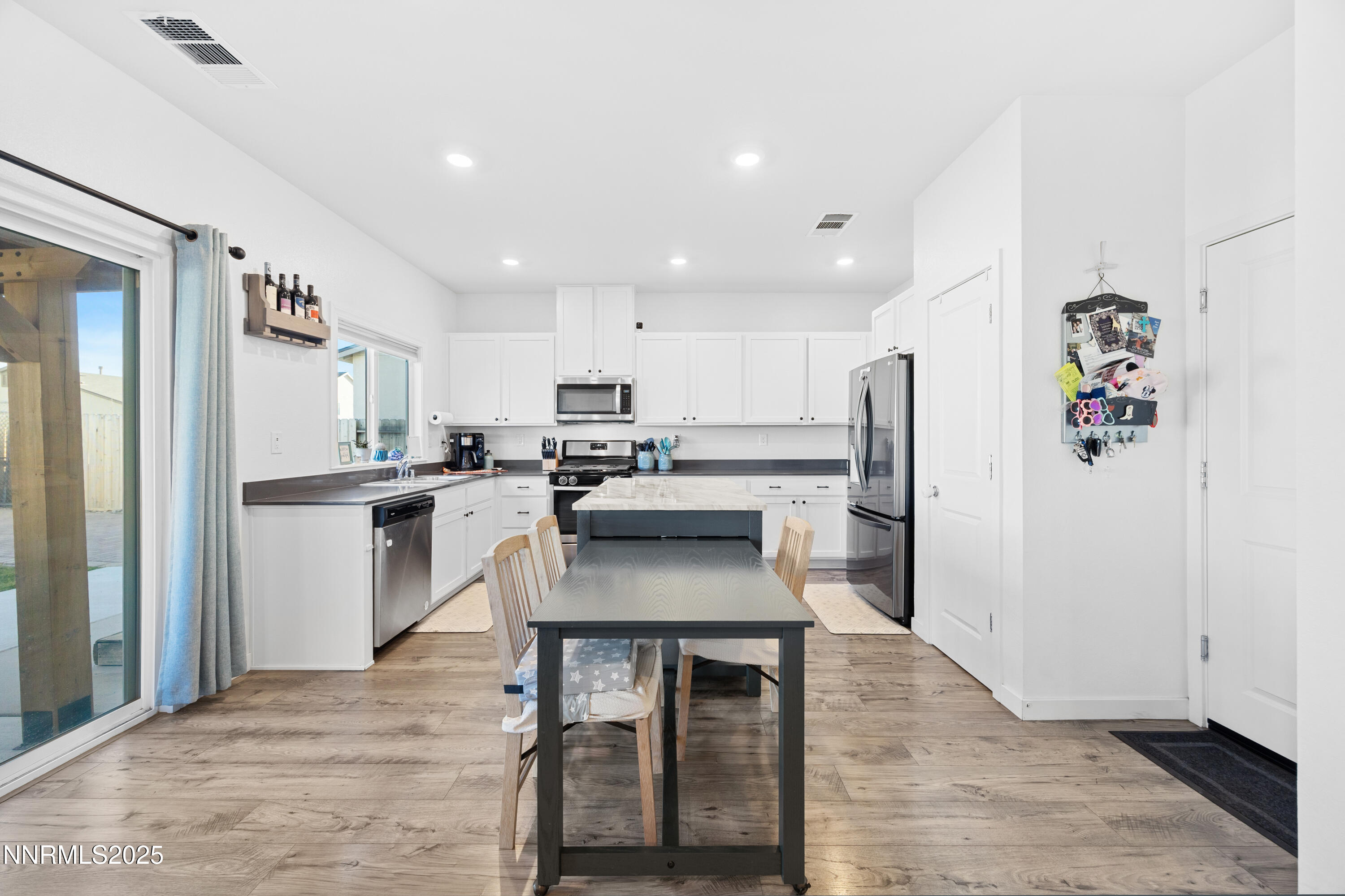 1383 Old Barn Road Sparks, NV 89436 - Photo 24 of 44 a kitchen with stainless steel appliances a dining table chairs refrigerator and microwave