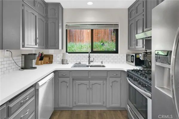 a kitchen with stainless steel appliances a sink stove and cabinets