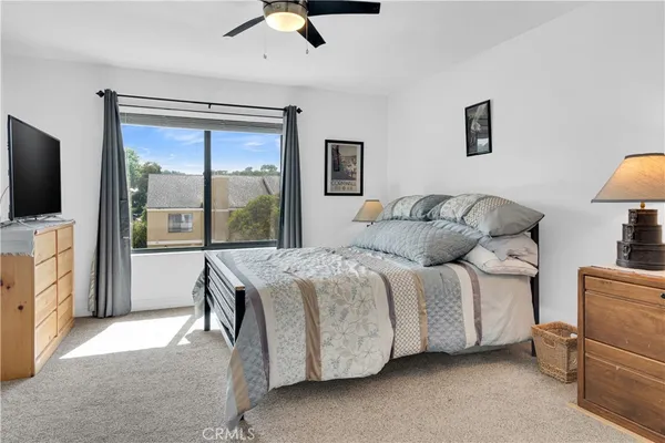 a bedroom with a balcony a bed and a flat tv screen on dresser