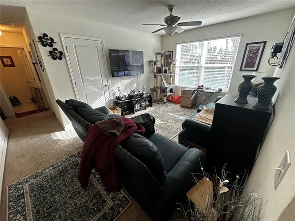 a living room with furniture a flat screen tv and a window