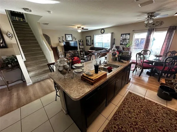 a living room with lots of furniture and a view of kitchen