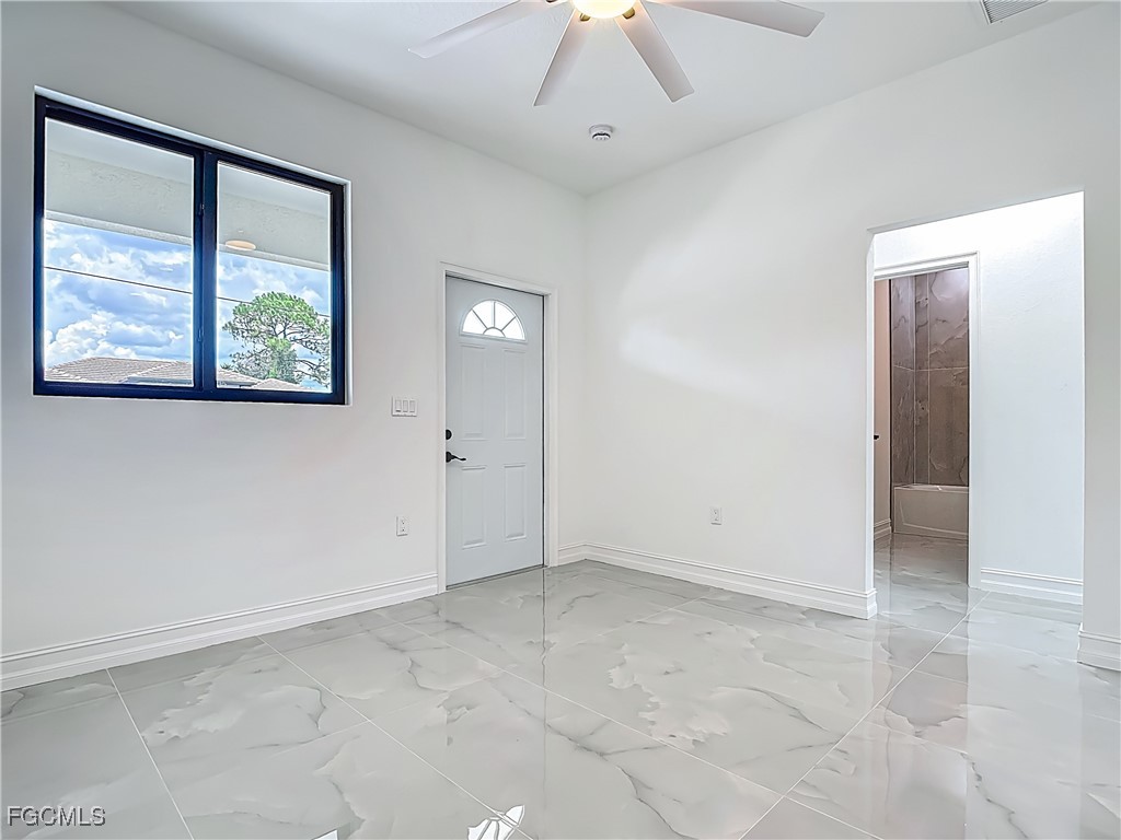 3705 8th Street Southwest Lehigh Acres, FL 33976 - Photo 11 of 34 an empty room with windows and fan