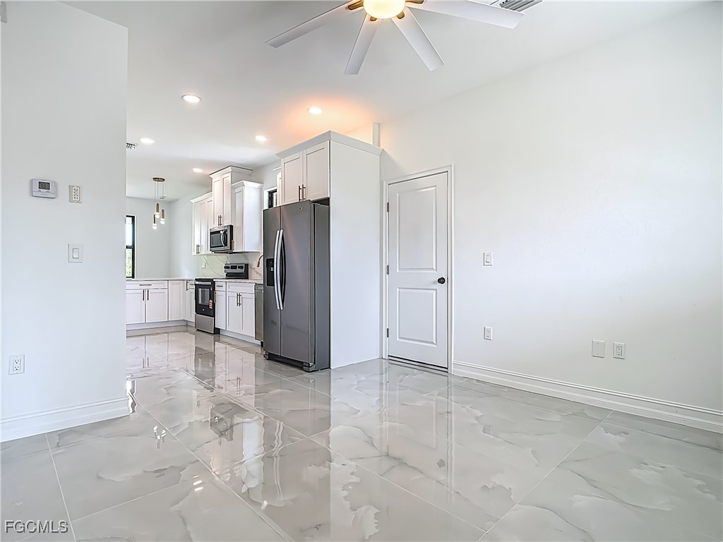 3705 8th Street Southwest Lehigh Acres, FL 33976 - Photo 7 of 34 a view of a refrigerator in kitchen and an empty room