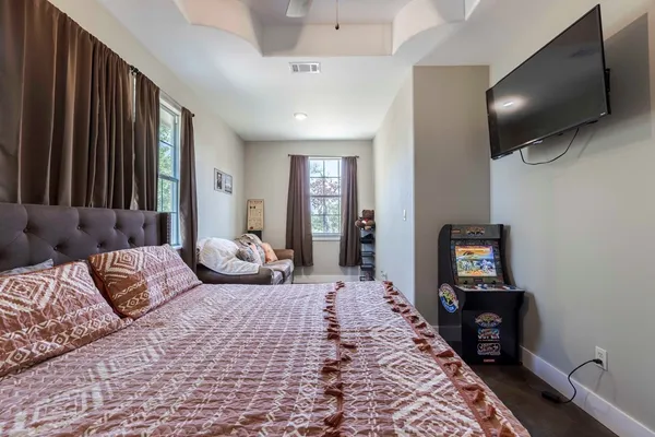 a bedroom with a large bed and a flat tv screen