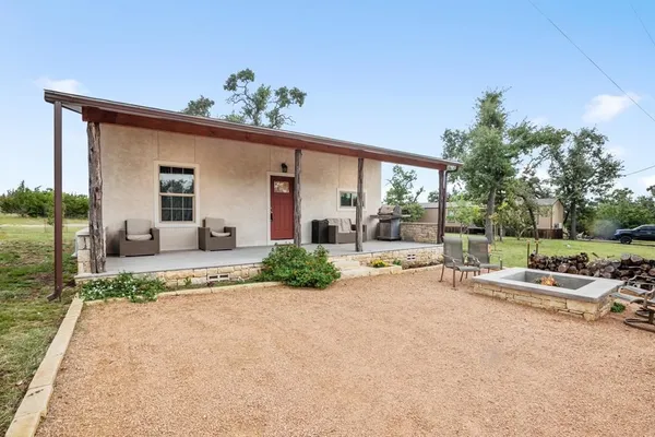 a view of a house with backyard and sitting area