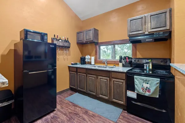 a kitchen with stainless steel appliances granite countertop a refrigerator a stove and a sink