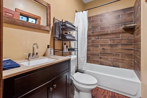 a bathroom with a sink a toilet and shower