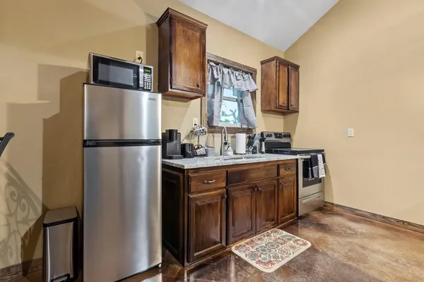 a kitchen with stainless steel appliances granite countertop a refrigerator a sink and a stove