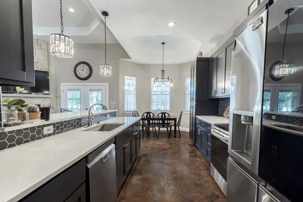 a large kitchen with lots of counter space a sink and stainless steel appliances