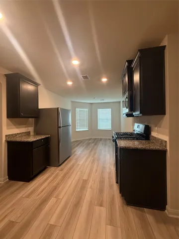a large kitchen with kitchen island granite countertop a sink and a stove top oven