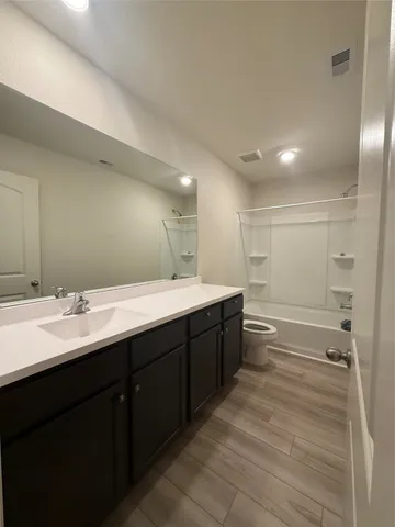 a bathroom with a double vanity sink a toilet and a mirror