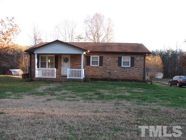 1857 Red Marshall Road Pelham, NC 27311 - Photo 1 of 18 a front view of a house with a yard and garage