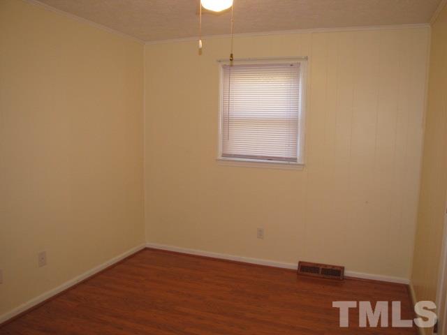 1857 Red Marshall Road Pelham, NC 27311 - Photo 8 of 18 an empty room with wooden floor and windows