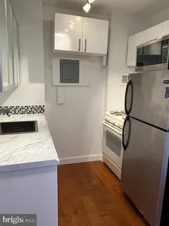 a kitchen with stainless steel appliances granite countertop a sink stove and microwave