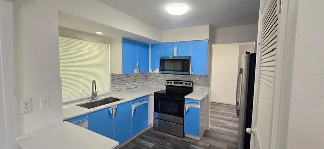 a kitchen with granite countertop a stove and a refrigerator
