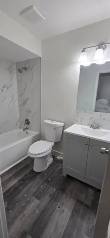 a bathroom with a double vanity sink toilet and shower
