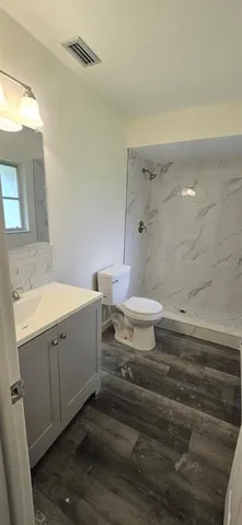 a bathroom with a double vanity sink toilet and shower